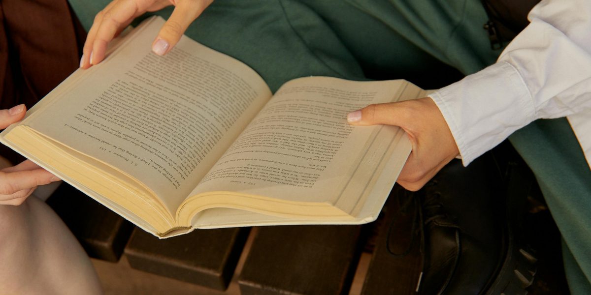 Friends animatedly discussing a book in a casual setting, sharing opinions and insights.