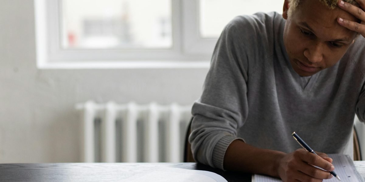 A person intently focused, writing notes or revising a manuscript, symbolizing the dedication and hard work behind great writing.