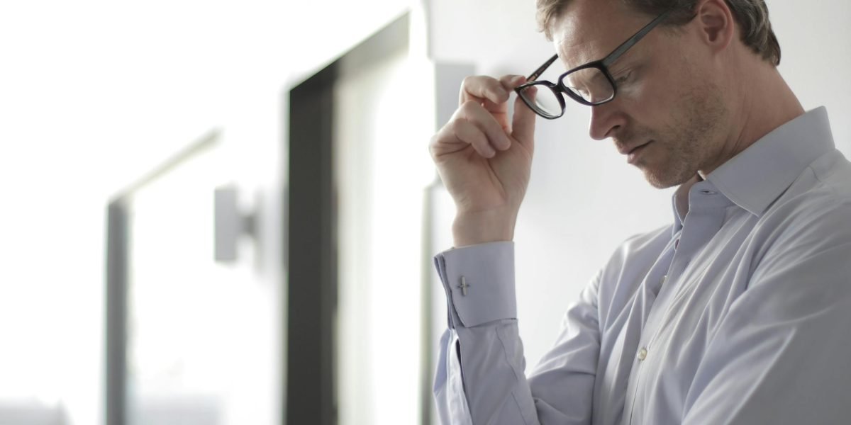 A person deep in thought, perhaps looking out a window or at a blank wall, symbolizing the internal struggle of making a high-stakes choice.
