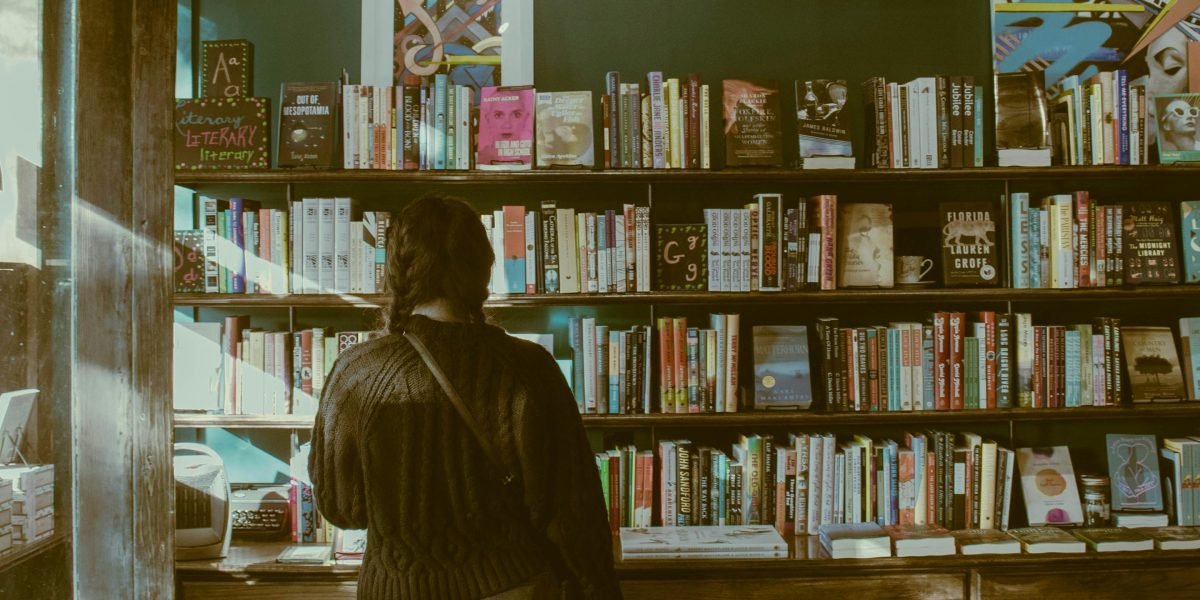 The classic experience of discovering a new book by browsing physical shelves in a traditional bookstore setting.