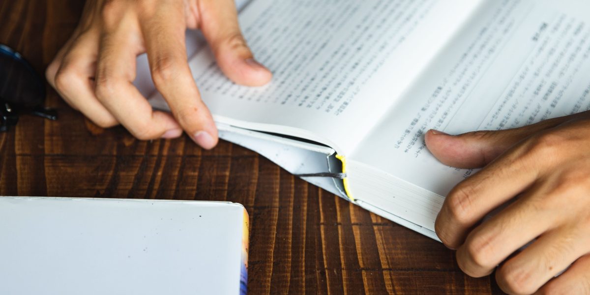 A reader engrossed in a book, pulled into the depths of a compelling dark fantasy world.